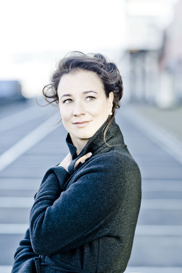 Fotografie einer jungen Frau, die lächelt und in die Ferne schaut